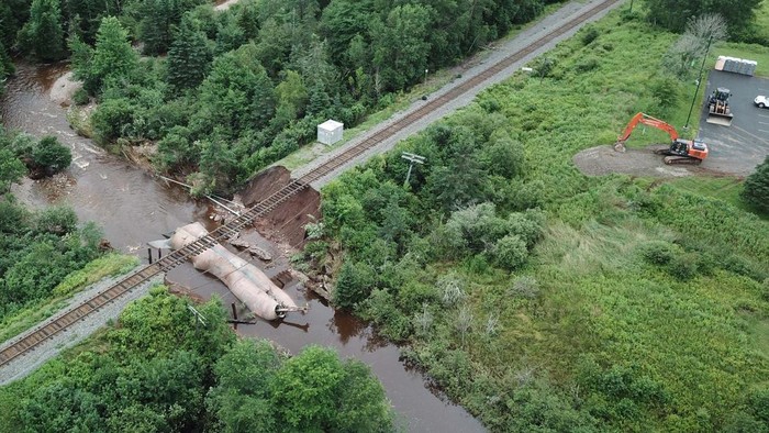 People embrace as they stand near damage to a road, after the heaviest rain to hit the Atlantic Canadian province of Nova Scotia in more than 50 years triggered floods, in Ellershouse, West Hants Regional Municipality, Nova Scotia, Canada July 23, 2023. REUTERS/John Morris