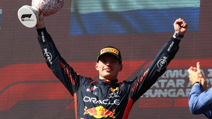 Formula One F1 - Hungarian Grand Prix - Hungaroring, Budapest, Hungary - July 23, 2023 Red Bulls Max Verstappen celebrates on the podium with the trophy after winning the Hungarian Grand Prix REUTERS/Bernadett Szabo