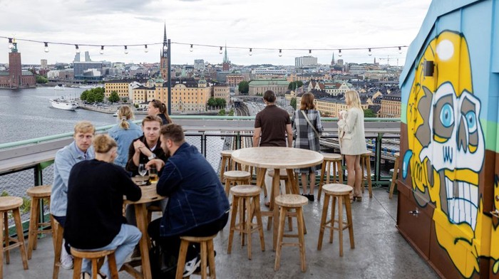 People have drinks and watch the view of the city from a rooftop bar in Stockholm, Sweden, July 19, 2023. TT News Agency/Ali Lorestani via REUTERS ATTENTION EDITORS - THIS IMAGE WAS PROVIDED BY A THIRD PARTY. SWEDEN OUT. NO COMMERCIAL OR EDITORIAL SALES IN SWEDEN.