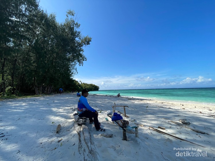 Meoskun, Pulau Sejuta Pesona Wisata di Raja Ampat Seorang wisatawan lokal duduk pantai Pulau Meoskun sambil menikmati pemandangan Raja Ampat