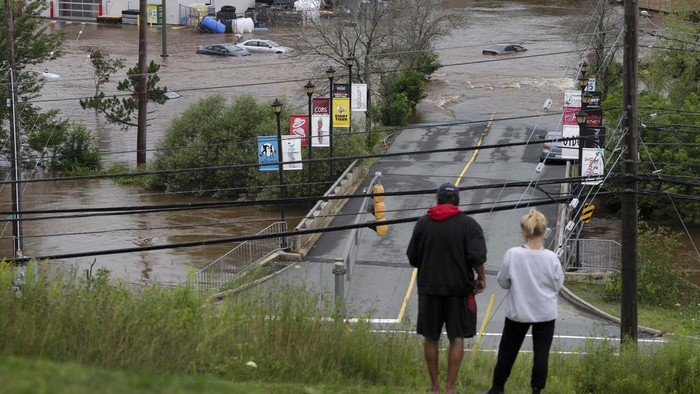 Penampakan Banjir Bandang yang Melanda Kanada A man wearing chest waders walks past cars abandoned in floodwaters in a mall parking lot following a major rain event in Halifax, Nova Scotia, Canada, on Saturday, July 22, 2023. (Darren Calabrese/The Canadian Press via AP)