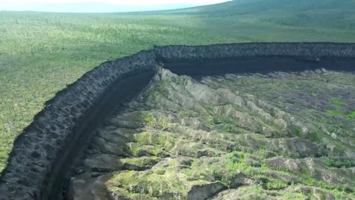 Penampakan Kawah Batagaika, 'Pintu Neraka' yang Makin Melebar A view of the Batagaika crater, as permafrost thaws causing a megaslump in the eroding landscape, in Russia's Sakha Republic in this still image from video taken July 11 or 12, 2023. Reuters TV via REUTERS