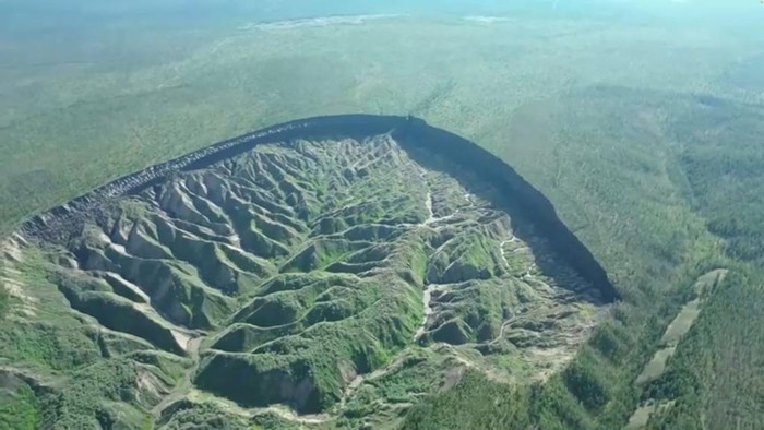 Penampakan Kawah Batagaika, 'Pintu Neraka' yang Makin Melebar A view of the Batagaika crater, as permafrost thaws causing a megaslump in the eroding landscape, in Russia's Sakha Republic in this still image from video taken July 11 or 12, 2023. Reuters TV via REUTERS