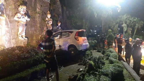 Posisi terakhir mobil Suzuki Splash putih DK 6550 GBJ yang menerobos Taman Sri Wedari, Tabanan, Bali, setelah dibentur mobil Xenia hitam DK 1536 IZ dalam kecelakaan pada Minggu (23/7/2023) malam. (istimewa)