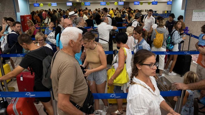 Ribuan Turis Terlantar di Bandara Rhodes Yunani Imbas Kebakaran Hutan Tourists line up at check-in counters as they wait for departing planes at the airport, after being evacuated following a wildfire on the island of Rhodes, Greece, July 24, 2023. REUTERS/Nicolas Economou TPX IMAGES OF THE DAY
