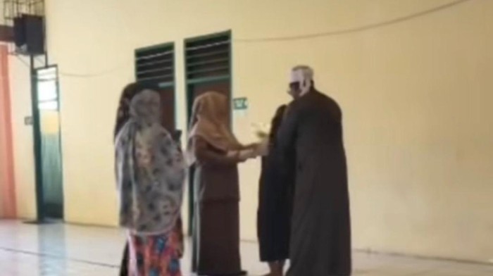 Siswa di SMPN 2 Parepare, Sulawesi Selatan (Sulsel) yang mengalami kesurupan ditangani oleh seorang ustaz.