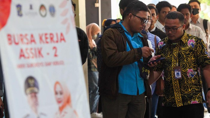 Bursa kerja ASSiK Pencari kerja mencari informasi lowongan saat Bursa Kerja ASSiK (Arek Suroboyo Siap Kerjo) di Surabaya, Jawa Timur, Selasa (25/7/2023). Bursa kerja yang digelar Pemkot Surabaya guna mengurangi angka pengangguran tersebut diikuti 50 perusahaan dengan menyediakan sekitar 1.300 lowongan kerja di dalam negeri dan luar negeri. ANTARA FOTO/Didik Suhartono/rwa.