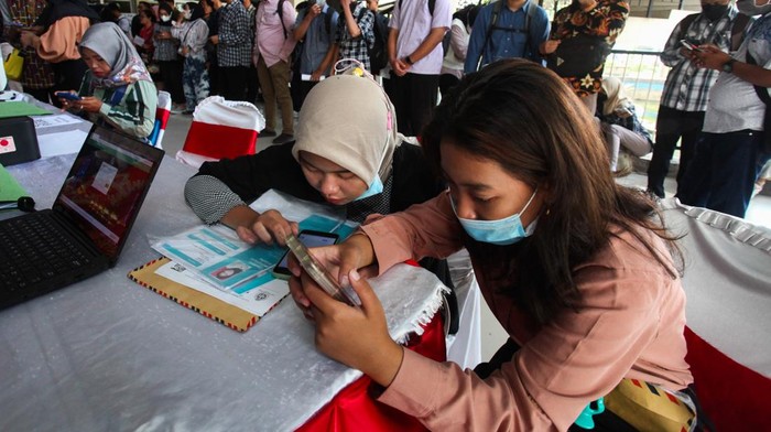 Bursa kerja ASSiK Pencari kerja mencari informasi lowongan saat Bursa Kerja ASSiK (Arek Suroboyo Siap Kerjo) di Surabaya, Jawa Timur, Selasa (25/7/2023). Bursa kerja yang digelar Pemkot Surabaya guna mengurangi angka pengangguran tersebut diikuti 50 perusahaan dengan menyediakan sekitar 1.300 lowongan kerja di dalam negeri dan luar negeri. ANTARA FOTO/Didik Suhartono/rwa.