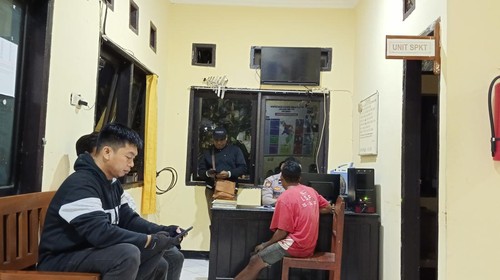 Frangkianus Bulu, kaos merah, saat membuat laporan dugaan penganiayaan pada dirinya di SPKT Polsek Maulafa, Kota Kupang, NTT, Senin malam (24/7/2023).