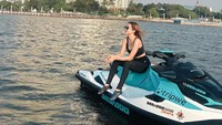 Ghea Youbi memakai celana panjang, tanktop, serta kacamata hitam saat main jetski. (Foto: dok Instagram)