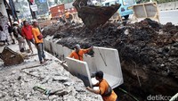 Pekerja melakukan perbaikan saluran air di jalan Otista, Jakarta Timur, Selasa (25/7/2023).  