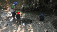 Warga mengambil air dari lubang yang dibuat di dasar sungai di Dukuh Karanganyar, Geyer, Grobogan, Jawa Tengah, Senin (24/7/2023). Warga yang sebulan lebih kesulitan air bersih karena kemarau, mengambil air dari dasar sungai yang mengering dan dimanfaatkan untuk mencuci, mandi hingga minum ternak, sementara kebutuhan minum warga membeli air. ANTARA FOTO/Yusuf Nugroho