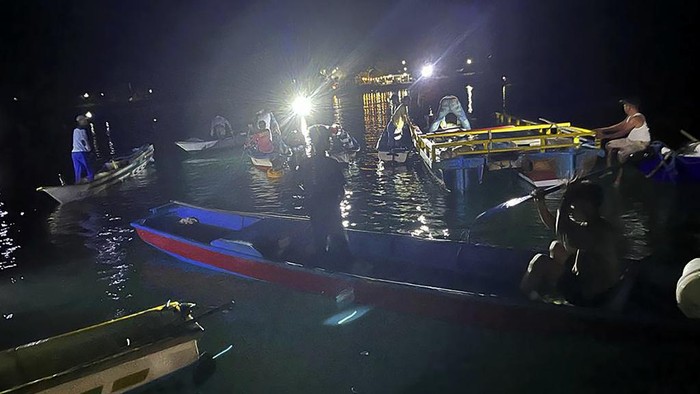 In this photo provided by the National Search and Rescue Agency (BASARNAS), rescuers on a rubber boat search for survivors after an overloaded ferry sank off Sulawesi Island, Indonesia, Monday, July 24, 2023. (BASARNAS via AP)