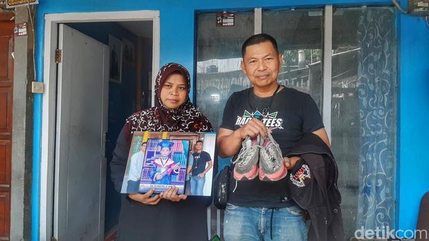 Orang tua menunjukkan sepatu bolong milik Zadani