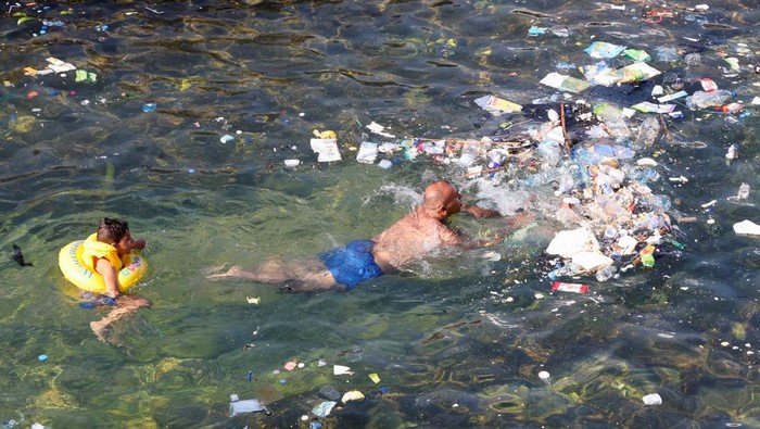 Panas Menyengat, Warga Lebanon Nekat Berenang di Laut Penuh Sampah People swim near trash floating in the water, in the Mediterranean Sea, in Beirut, Lebanon July 24, 2023. REUTERS/Mohamed Azakir