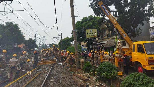 Petugas ganti tiang listrik KRL yang rusak ditabrak truk (Kurniawan-detikcom)