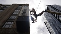 A workman removes characters from a sign on the Twitter headquarters building in San Francisco, Monday, July 24, 2023. Elon Musk has unveiled a new 