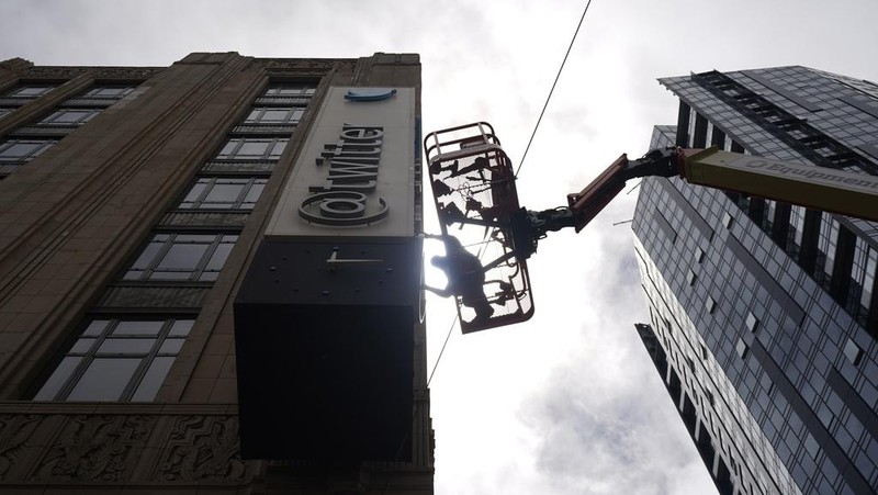 A workman removes characters from a sign on the Twitter headquarters building in San Francisco, Monday, July 24, 2023. Elon Musk has unveiled a new 