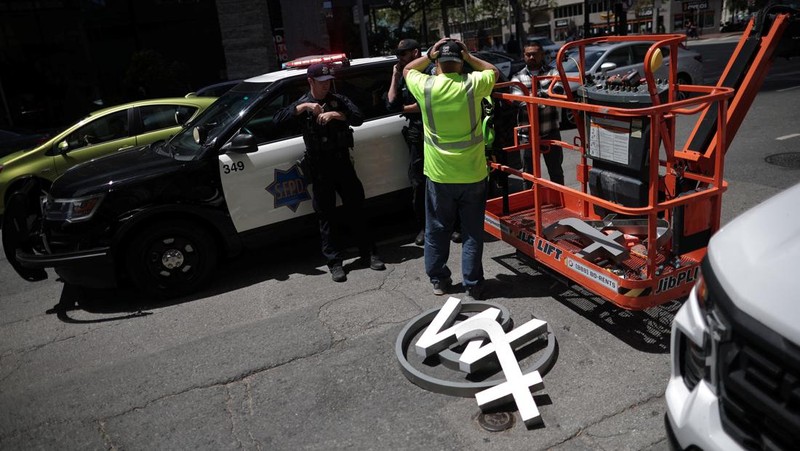 A worker uses a smartphone while dismantling a Twitter's sign at Twitter's corporate headquarters building as Elon Musk renamed Twitter as X and unveiled a new logo, in downtown San Francisco, California, U.S., July 24, 2023. REUTERS/Carlos Barria TPX IMAGES OF THE DAY