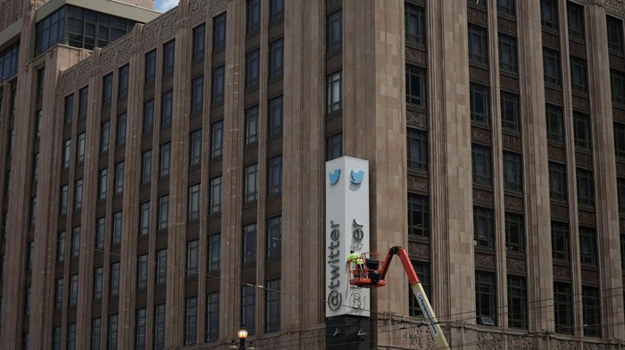 A worker uses a smartphone while dismantling a Twitters sign at Twitters corporate headquarters building as Elon Musk renamed Twitter as X and unveiled a new logo, in downtown San Francisco, California, U.S., July 24, 2023. REUTERS/Carlos Barria TPX IMAGES OF THE DAY
