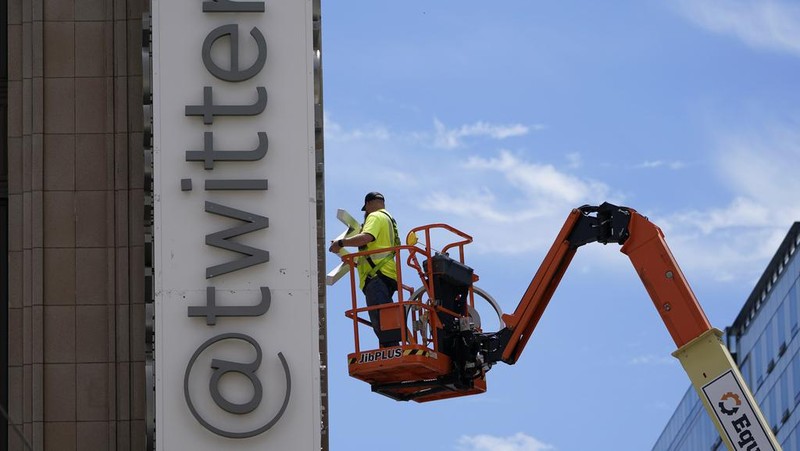 A workman removes a character from a sign on the Twitter headquarters building in San Francisco, Monday, July 24, 2023. Elon Musk has unveiled a new 
