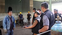 Petugas memeriksa seorang pekerja di sebuah pabrik pengolahan kelapa sawit saat digelarnya razia tenaga kerja asing di kawasan Berikat Lubuk Gaung Dumai, Riau.  