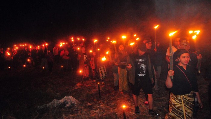 Warga berdoa bersama saat mengikuti tradisi Lamporan di bukit Alang-alang Pegunungan Kendeng, Desa Kedumulyo, Sukolilo, Pati, Jawa Tengah, Senin (24/7/2023). Tradisi yang digelar para petani pada bulan Sura tersebut selain sebagai ungkapan syukur kepada Tuhan YME atas panen yang melimpah, juga sebagai simbol untuk tolak bala hama pertanian serta bentuk penolakan pada kebijakan pemimpin yang merugikan petani. ANTARA FOTO/Yusuf Nugroho/rwa.