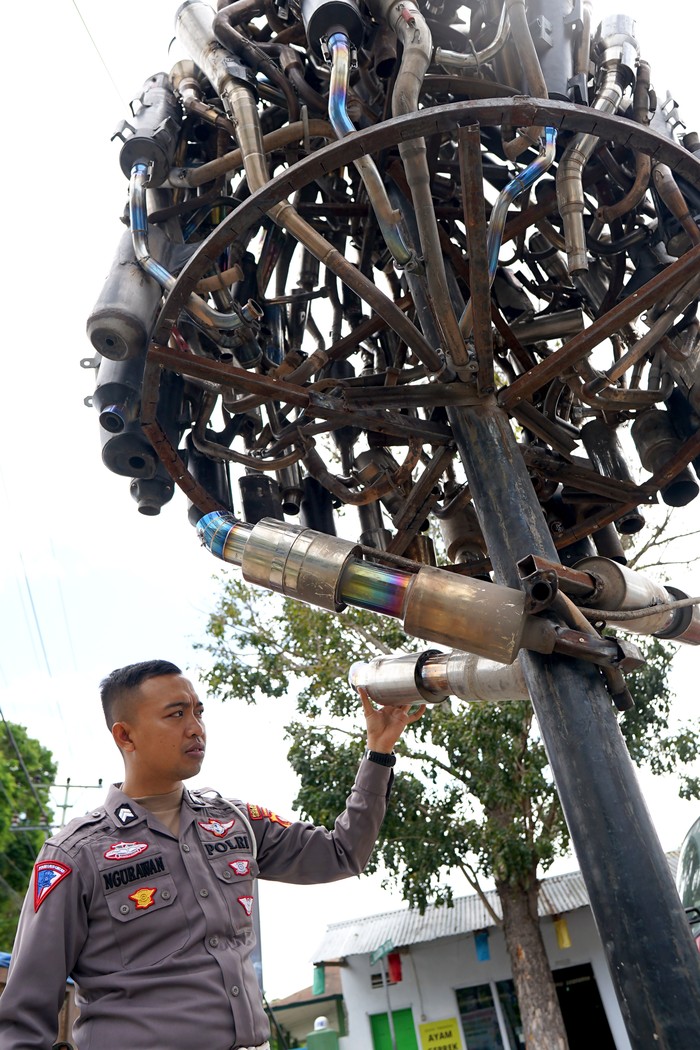 Tugu knalpot hasil Operasi Patuh Seorang anggota Polisi Lalu Lintas menunjukkan tugu knalpot yang dibangun di depan kantor Satuan Lalu Lintas Polresta Gorontalo Kota, Kota Gorontalo, Gorontao, Selasa (25/7/2023). Satlantas membangun tugu knalpot brong dari 59 barang bukti hasil razia Operasi patuh Otanaha 2023 sebagai pengingat dan imbauan kepada masyarakat untuk tidak menggunakan knalpot bising pada kendaraan bermotor. ANTARA FOTO/Adiwinata Solihin/rwa.
