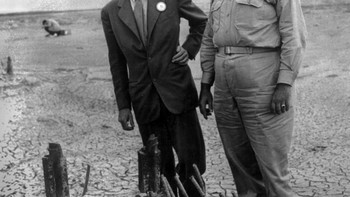 Pada gambar ini tampak Oppenheimer dan Groves memeriksa sisa-sisa salah satu dasar menara uji baja. Foto: Atomicarchive