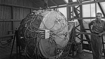 Norris Bradbury, pemimpin kelompok perakitan bom, berdiri di samping perangkat yang dirakit sebagian di atas menara uji. Di kemudian hari, setelah kepergian Oppenheimer, ia menjadi direktur Los Alamos. Bradbury menjabat sebagai direktur selama beberapa dekade. Foto: Atomicarchive