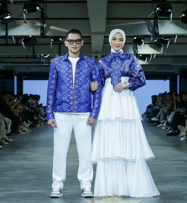 Citra Kirana dan Rezky Aditya juga ditunjuk jadi model untuk koleksi Renzi Lazuardi yang bertema ‘Mabelo’. Keduanya tampil serasi dengan busana biru motif tenun dan bawahan putih. Foto: Dok. JF3