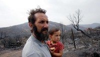 Amar Belkati suami dari Souhila Belkati yang juga seorang petani melihat area hutan yang terbakar.  