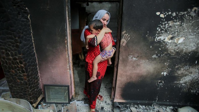 Duka Warga yang Rumahnya Hangus Akibat Kebakaran Hutan di Aljazair Souhila Belkati carries her child inside her burnt house, following a wildfire in Bejaia, Algeria July 25, 2023. REUTERS/Ramzi Boudina TPX IMAGES OF THE DAY