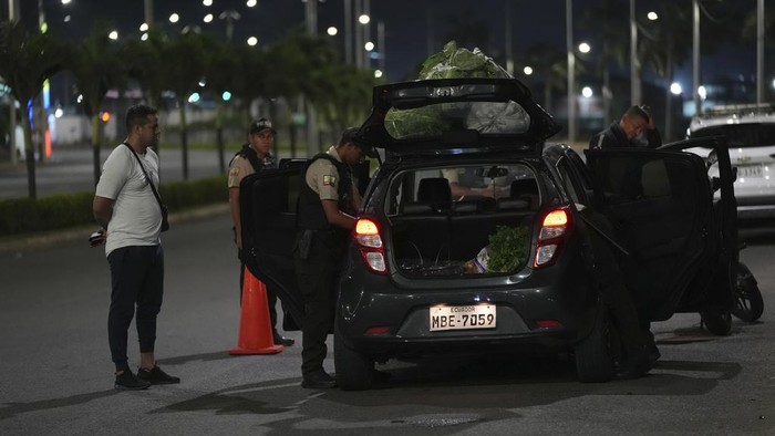 Police stand on a median during the start of a curfew decreed by Ecuador´s President Guillermo Lasso to try to reduce the ongoing wave of violence in Manta, Ecuador, Monday, July 24, 2023. (AP Photo/Dolores Ochoa)