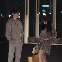 Tak kalah gemas. Yoona memakai baju couple dengan Lee Junho dari koleksi Thom Browne, jersey sweater abu-abu seharga $643 (Rp 9 jutaan) dan mini skirt $790 (Rp 11 jutaan) dengan koleksi sling bag dan sneakers Miu Miu. Foto: dok. Netflix