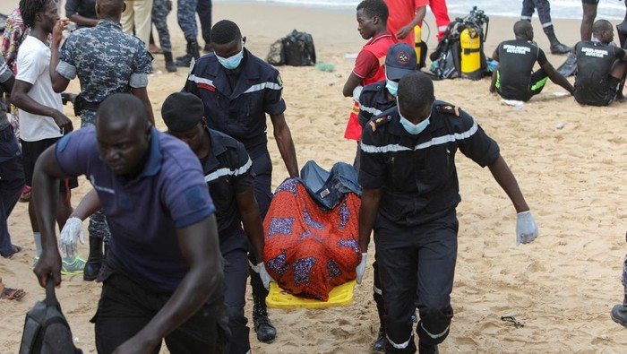 Kapal Migran Terbalik di Lepas Pantai Senegal, 17 Orang Tewas Firefighters transport a body away from the beach of Ouakam, where a boat transporting migrants, attempting irregular immigration, has run aground off the coast, Dakar, Senegal, July 24, 2023. REUTERS/Ngouda Dione TPX IMAGES OF THE DAY
