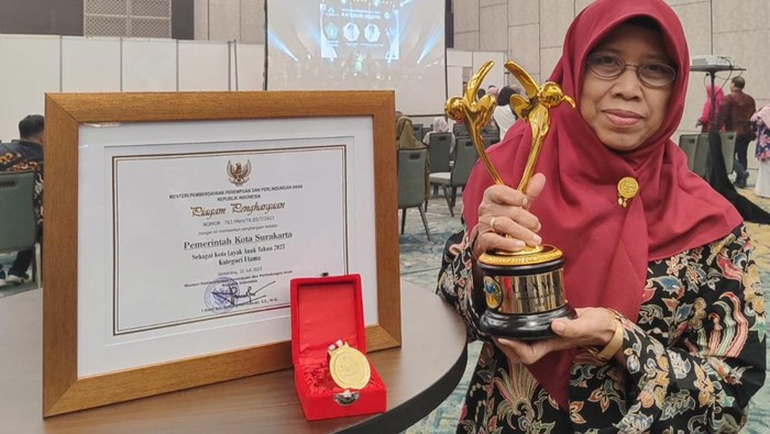 Kepala DP3AP2KB Kota Solo, Purwanti memperlihatkan penghargaan Kota Layak Anak yang diterima Kota Solo. Foto diunggah Rabu (26/7/2023).