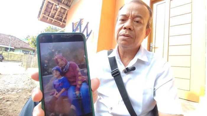 Kepala Dusun Selaawi menunjukan foto mama muda dan anaknya yang hilang sejak 4 hari.