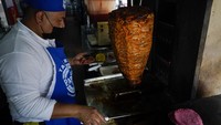 Seorang juru masak menyiapkan taco dengan tortilla merah muda bertema Barbie di sebuah restoran di Mexico City, Kamis, 20 Juli 2023.