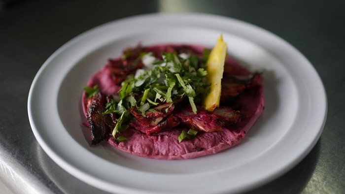 A cook prepares a taco with a Barbie themed pink tortilla at a restaurant in Mexico City, Thursday, July 20, 2023. The restaurant is offering tacos to its customers, made with these Barbie-themed tortillas where the corn dough is colored pink with beet juice. (AP Photo/Eduardo Verdugo)