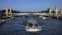 Kapal pesiar tongkang melewati jembatan Alexandre III. Jembatan ini termasuk jembatan romantis, di mana banyak pasangan melakukan foto pra nikah. AP/Michel Euler  
