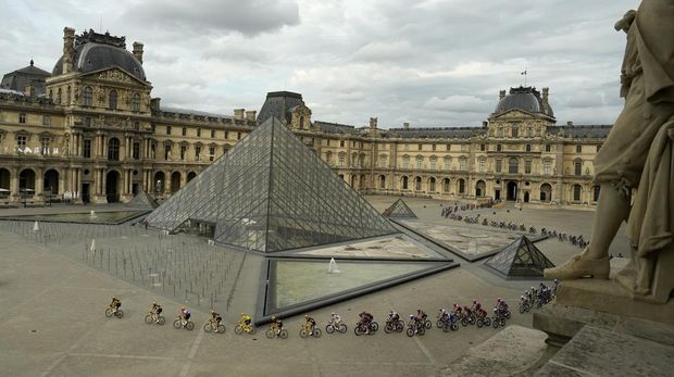 The pack with Denmark's Jonas Vingegaard, wearing the overall leader's yellow jersey passes the Louvre Museum during the twenty-first stage of the Tour de France cycling race over 115 kilometers (71.5 miles) with start in Saint-Quentin-en-Yvelines and finish on the Champs-Elysees in Paris, France, Sunday, July 23, 2023. (AP Photo/Lewis Joly, Pool)
