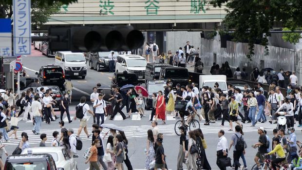 Orang-orang berjalan melintasi penyeberangan pejalan kaki di distrik Shibuya dalam cuaca panas dan lembab Kamis, 13 Juli 2023, di Tokyo. (AP Photo/Eugene Hoshiko)