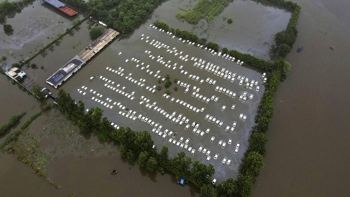 Hujan deras mengakibatkan Sungai Hindon, India, meluap, Rabu (26/7/2023). Selain membanjiri rumah, luapan sungai juga merendam gudang mobil di Greater Noida.