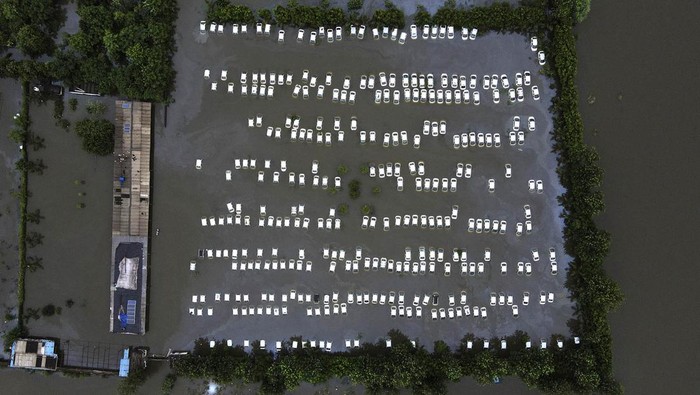 Hujan deras mengakibatkan Sungai Hindon, India, meluap, Rabu (26/7/2023). Selain membanjiri rumah, luapan sungai juga merendam gudang mobil di Greater Noida.