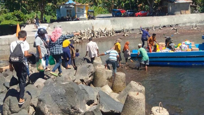 Sejumlah warga dari Kecamatan Pulau Hiri berjalan di atas bebatuan karang saat air laut surut, di Ternate, Maluku Utara.