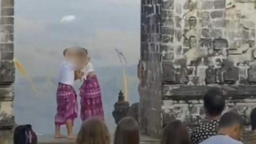 Tangkapan layar video sepasang bule viral di media sosial lantaran ciuman mesra saat berfoto di candi bentar Pura Lempuyang, Karangasem, Bali.