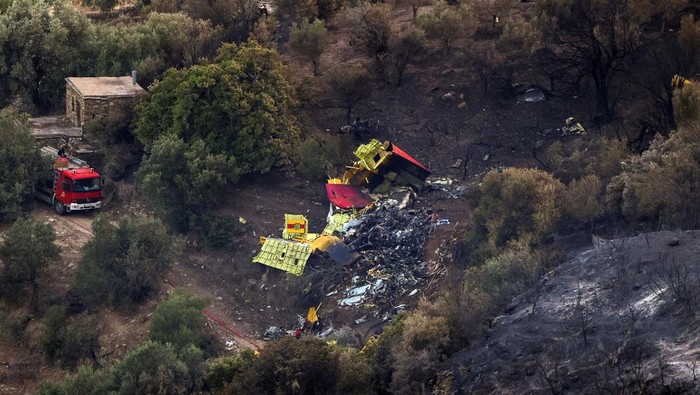 Rescuers operate at the crash site of a firefighting plane that crashed after a water drop as a wildfire burns near the village of Platanistos, on the island of Evia, Greece, July 25, 2023. REUTERS/Stelios Misinas REFILE - CORRECTING NAME OF THE ISLAND from EVIL TO EVIA