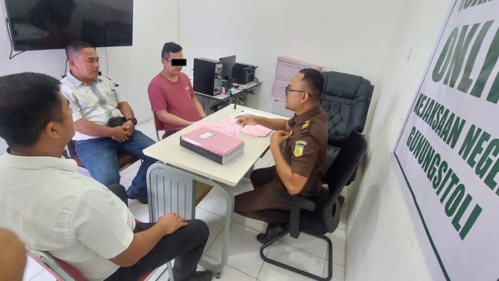 Tersangka PNS saat diserahkan ke Kejari Gunung Sitoli.