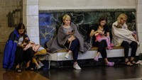 Para wanita berlindung di dalam stasiun kereta bawah tanah bersama anak-anak mereka, selama peringatan serangan udara, di tengah serangan Rusia di Ukraina, di Kyiv, Rabu (26/7/2023).